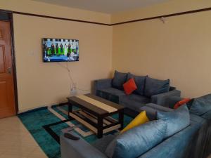 a living room with a couch and a table at Milimani Nanyuki in Nanyuki