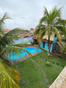 einen Luftblick auf ein Resort mit einem Pool in der Unterkunft Casa de Praia Suítes in Saquarema