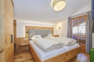 a bedroom with a bed with white sheets and a window at Gästehaus Angerer in Reit im Winkl