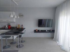 a kitchen with a table and a tv on a wall at Gesyl Apartment in Tolo