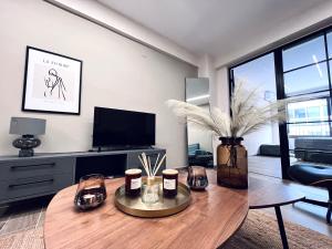 a living room with a table and a tv at Modiano Luxury Apartment Thessaloniki in Thessaloniki