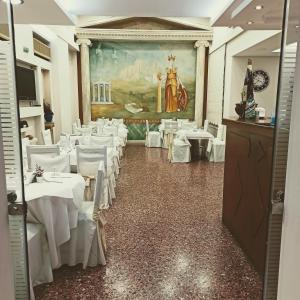 un comedor con mesas blancas y sillas blancas en Hotel Solomou Athens, en Atenas