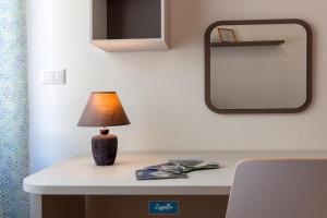 eine Lampe auf einem Tisch mit einem Spiegel in der Unterkunft Zezzella Tourist Lease in Locorotondo