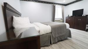 um quarto com uma cama e uma mesa de vidro em Algonquin Lakeside Inn em Dwight