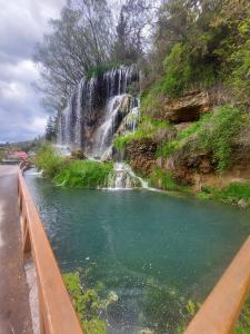 a waterfall and a pool of water next to a road at Apartament Panoramic Toplița in Topliţa