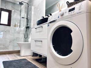 a white washing machine in a bathroom with a shower at Modiano Luxury Apartment Thessaloniki in Thessaloniki +7 photos