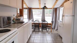 a kitchen with white cabinets and a table with chairs at Algonquin Lakeside Inn in Dwight