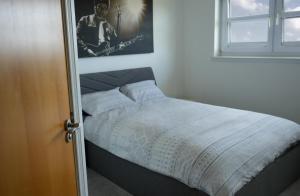 a bed in a bedroom with a picture on the wall at Modern Apartment Ayr Town Centre in Prestwick