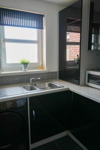 a kitchen with a sink and a window at Modern Apartment Ayr Town Centre in Prestwick