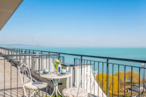 a balcony with a table and chairs and the ocean at MF Lux Penthouse in Siófok