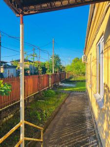 an empty street next to a building with a fence at Чёрное Море in Ochamchira