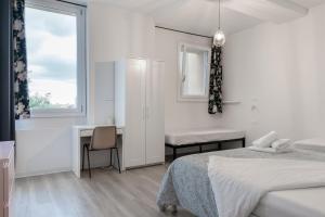 a white bedroom with a bed and a desk at Saragozza Apartments in Bologna