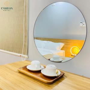 um espelho sobre uma mesa com duas xícaras e pires em Camelia 108 Le Lai Hotel em Ho Chi Minh