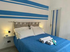 - une chambre avec un lit bleu et des serviettes dans l'établissement Affittacamere Via Prione, à La Spezia