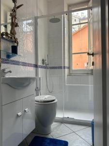 La salle de bains blanche est pourvue d'une douche et de toilettes. dans l'établissement Affittacamere Via Prione, à La Spezia