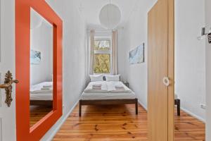 Habitación pequeña con cama y espejo. en primeflats - Apartment Togo Berlin-Wedding, en Berlín