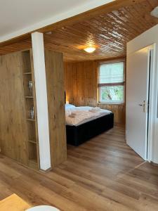 a bedroom with a bed in a room with wooden walls at Seeblick Apartment am Mellensee in Mellensee