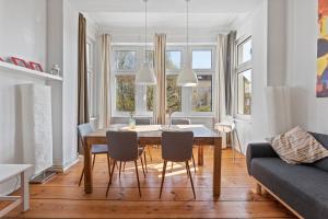a dining room and living room with a table and chairs at primeflats - Apartment Togo Berlin-Wedding in Berlin