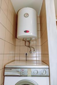 eine Waschmaschine und einen Trockner in einem gefliesten Bad mit einer Lampe in der Unterkunft To Petrino 