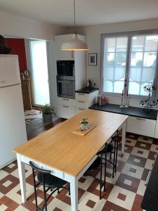 een keuken met een houten tafel en een aantal stoelen bij Chez Viviane in Fontaine-Étoupefour