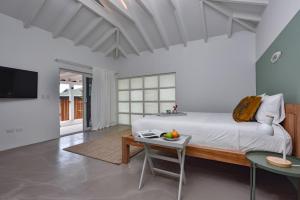 a bedroom with a bed and a table and a tv at Koeriboeri Aruba Lodges in Babijn