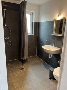 a bathroom with a sink and a shower and a toilet at Seeblick Apartment am Mellensee in Mellensee +63 photos