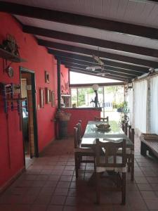 comedor con mesa y pared roja en La Casita en Chascomús