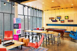 a restaurant with tables and chairs and pool tables at Aloft Beachwood in Beachwood