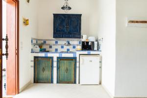- une cuisine avec des placards en bois et un réfrigérateur dans l'établissement Ficus Traditional Apartments, à Kefalos