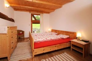 1 dormitorio con cama de madera y ventana en Botenhof - Urlaub auf dem Bauernhof - Agriturismo, en Sarentino