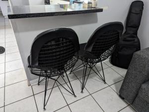 duas cadeiras pretas sentadas ao lado de um balcão em @Kitchens em Jeffreys Bay