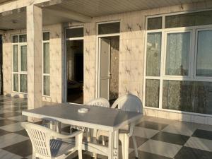 stół i krzesła siedzące na patio z domem w obiekcie Merab House w mieście Batumi