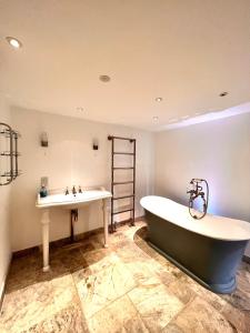 a bathroom with a bath tub and a sink at Knightsbridge villa, Westminster in London