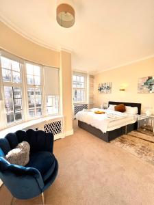 een grote slaapkamer met een bed en een stoel bij Knightsbridge villa, Westminster in Londen