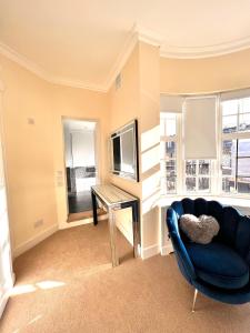 een woonkamer met een blauwe bank en een tafel bij Knightsbridge villa, Westminster in Londen