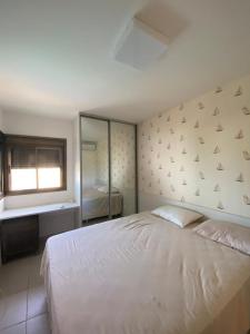 Un dormitorio con una gran cama blanca y una ventana en Ekoara Residence - Muro Alto, en Porto de Galinhas