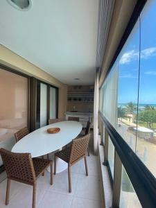 uma sala de jantar com uma mesa branca e cadeiras em Ekoara Residence - Muro Alto em Porto de Galinhas