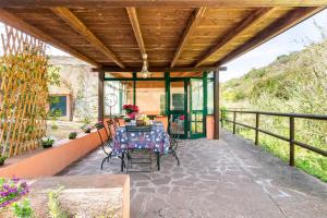 un patio al aire libre con mesa y sillas en The Old Mill with Private Garden and Torrent, en Portoferraio