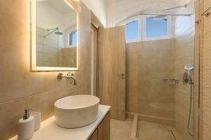 a bathroom with a sink and a shower at Sea Breeze Studios Paros in Aliki
