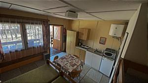 eine kleine Küche mit einem Tisch und einem Waschbecken in der Unterkunft Šiška Kemp in Doksy