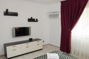 een woonkamer met een tv en een rood gordijn bij studio casa 3 in Galaţi