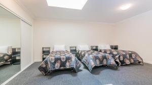 two beds in a white room with at 1-83 Thompson Avenue, Cowes in Cowes