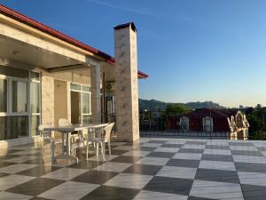 a patio with a table and chairs on a tile floor at Merab House in Batumi