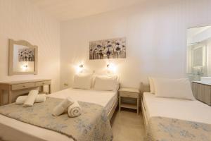 a bedroom with two beds and a window at Sea Breeze Studios Paros in Aliki