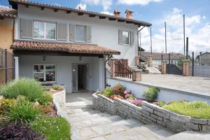 a house with a stone retaining wall in front of it at La casa del Pue in Bene Vagienna