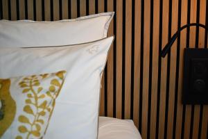 Una cama con dos almohadas encima. en Le Cheval Blanc - Lac du Der - Logis Hotel, en Giffaumont-Champaubert