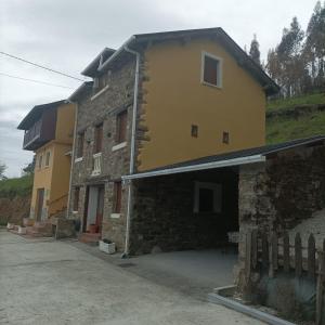 un gran edificio amarillo con una entrada delante de él en EL MEJICANO, en Trevías