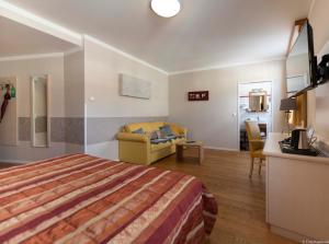 a hotel room with a bed and a living room at Winzerhotel Gumpoldskirchen in Gumpoldskirchen
