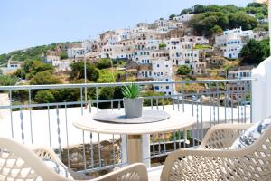 een tafel en stoelen op een balkon met uitzicht bij VOLTO Suite in Kóronos