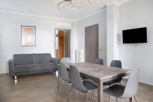 ein Esszimmer mit Tisch und Stühlen und einer Couch in der Unterkunft Il Riccio e la Castagna in Montaldo Roero